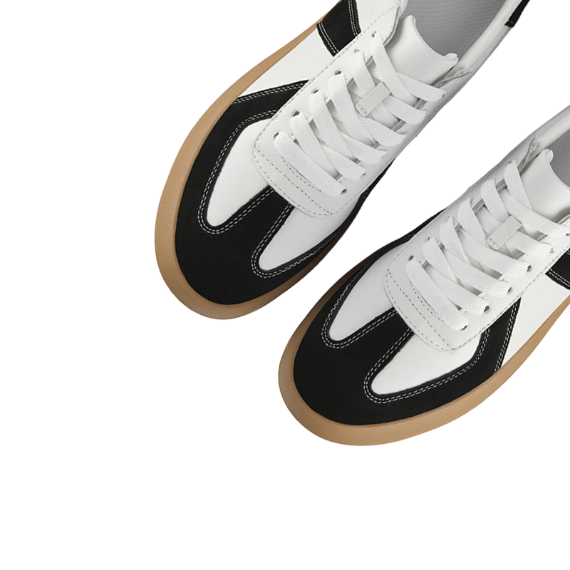 Black and white sneakers with brown soles on a white background