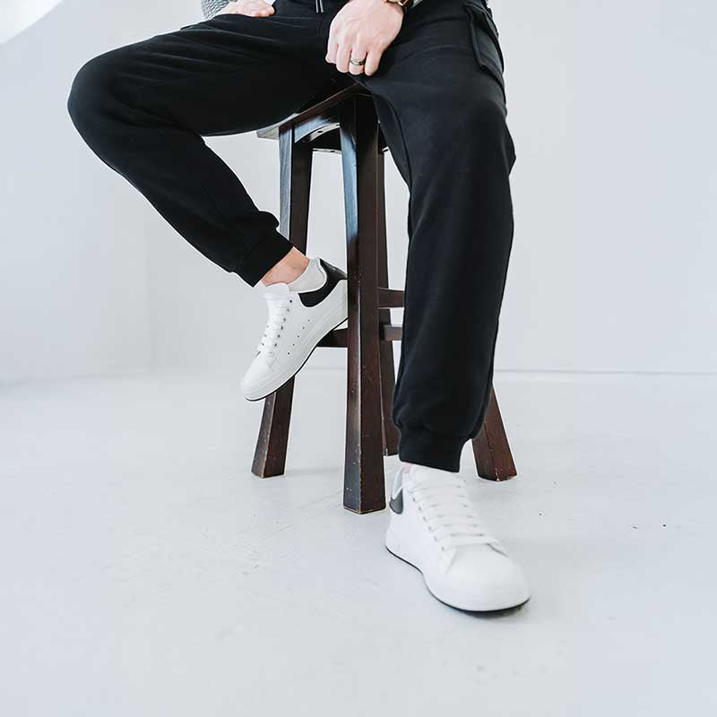 Man Sitting In White Vibe Elevator Sneakers