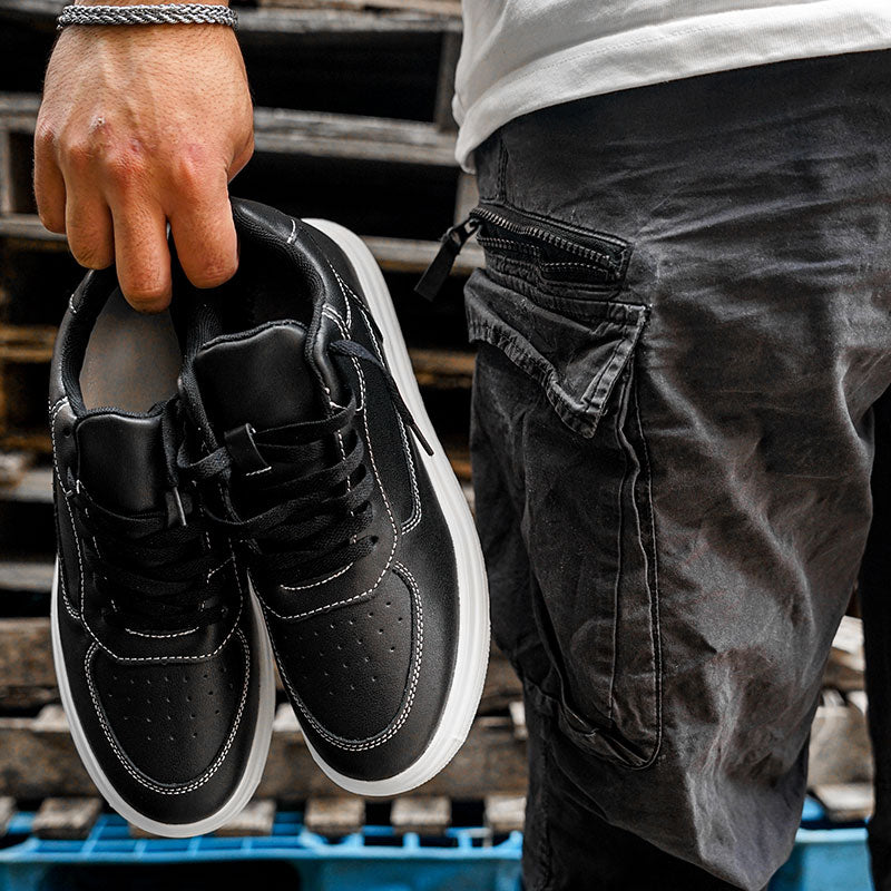 Man Holding a Pair of Novo Black Elevator Sneakers | Levante Shoes