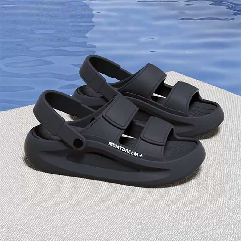 Grey elevator sandals with straps on a poolside surface