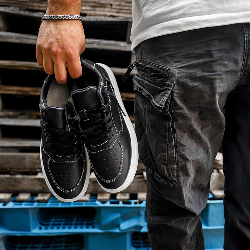 Man holding a pair of elevator sneakers