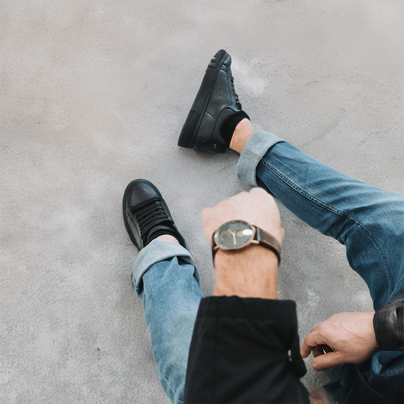 Man sitting in Levante Vibe black elevator sneakers with hidden height increase