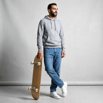 Man holding a skateboard against a plain background