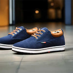 Blue casual shoes with brown accents on a tiled floor