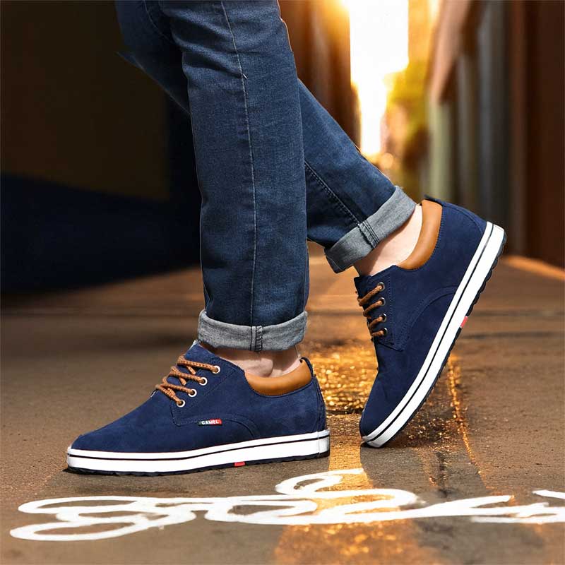 Blue sneakers with brown soles worn with blue jeans on a blurred street background