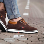 Brown shoes with white soles worn on a paved surface