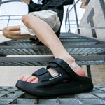 Person wearing black EVA elevator sandals on a metal staircase.