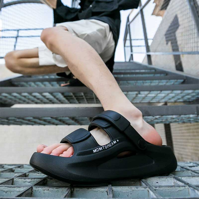 Person wearing black EVA elevator sandals on a metal staircase.