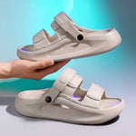 Khaki elevator sandals with purple lighting held by a hand against a gradient blue studio background