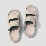 Top view of pair of khaki elevator slides on a light gray background