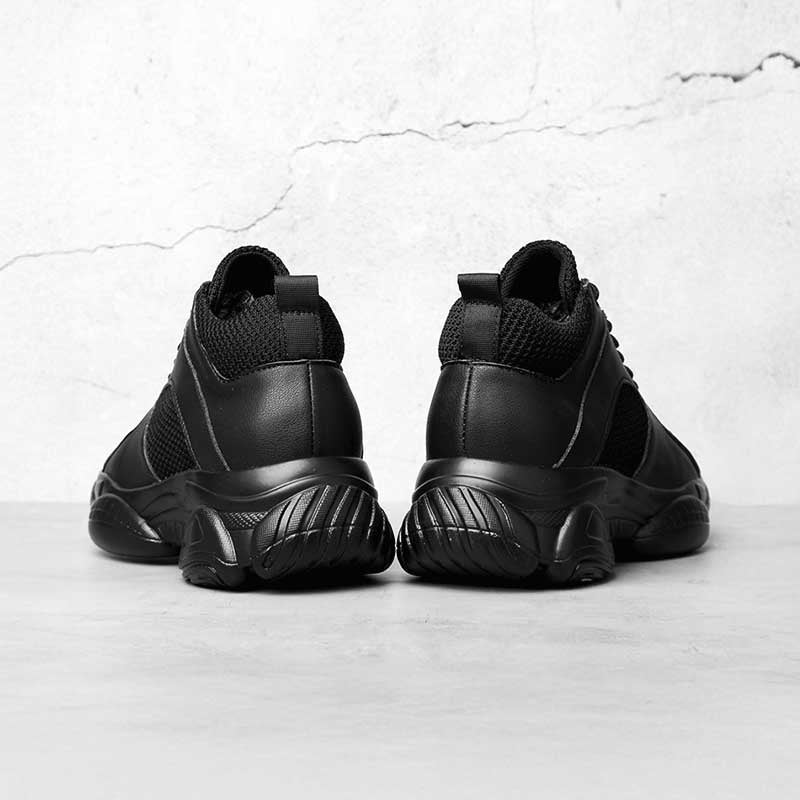 Black high-top elevator sneakers on a light grey background