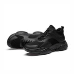 Black athletic style elevator trainers on a white background