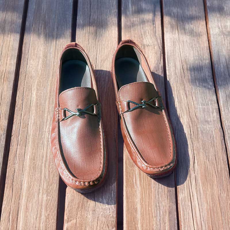 Pair of brown leather loafers on a wooden surface