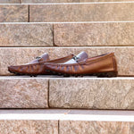Pair of brown loafers on a stone surface